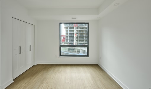 an empty room with a large window and white walls