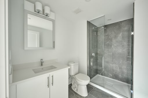 a white bathroom with a shower toilet and sink