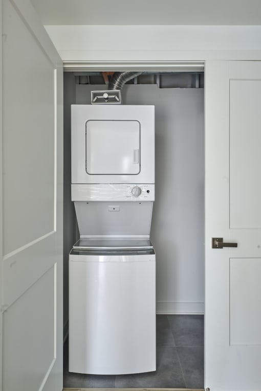 a white washer and dryer in a white closet