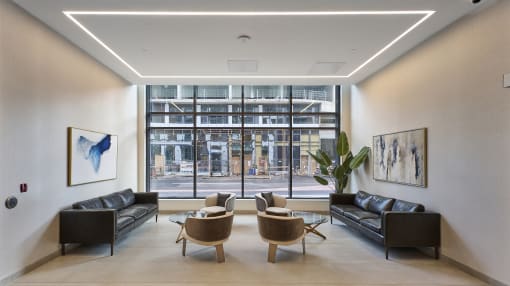 a living room with leather couches and chairs and a large window