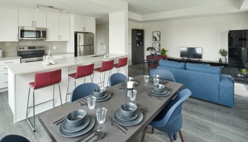 a kitchen and living room with a dining table and chairs
