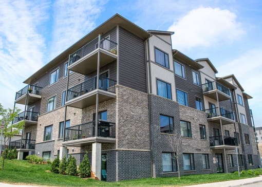a brick apartment building with balconies on a sunny day