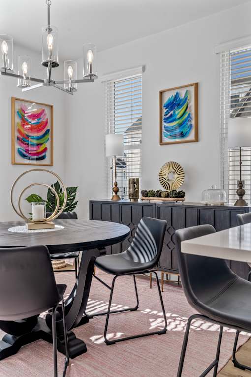 A modern dining room with a round table and chairs.