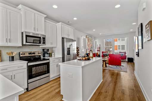 A modern kitchen with white cabinets and stainless steel appliances.