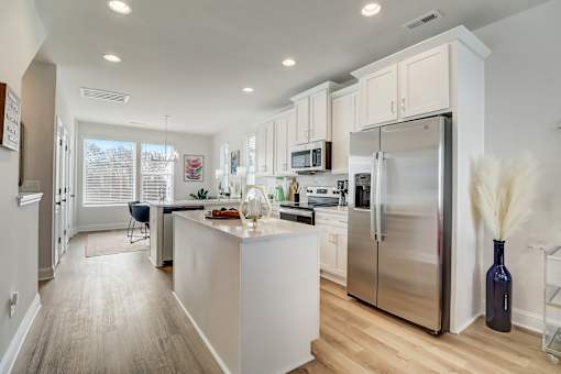 A kitchen with a white island and stainless steel appliances.