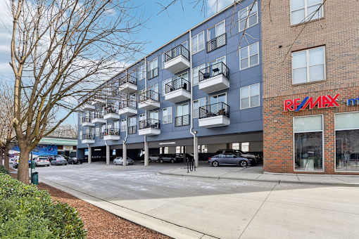 A RE/MAX real estate office is located in a multi-story apartment building.