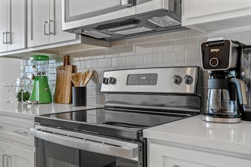 A modern kitchen with a stove top and a coffee maker.