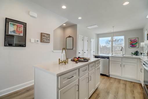A kitchen with white cabinets and a large island.