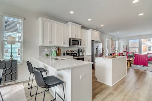A modern kitchen with white cabinets and a large island.