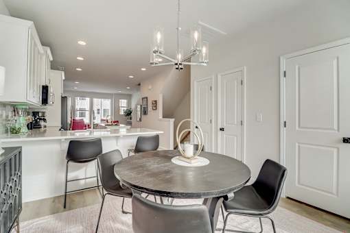 A modern dining room with a round table and chairs.