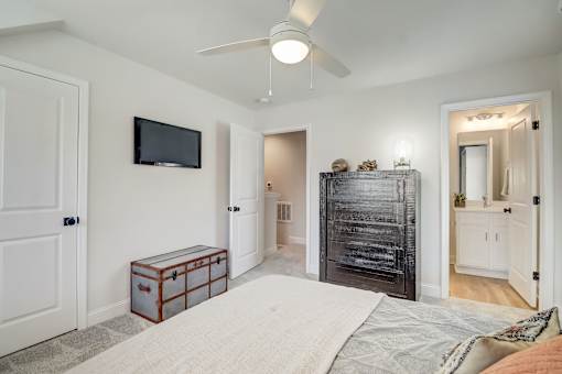 A bedroom with a bed, dresser, and mirror.
