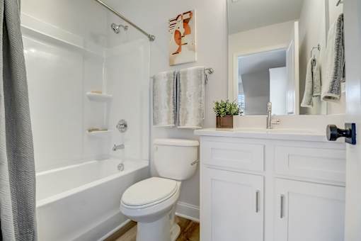 A white bathroom with a toilet, sink, and bathtub.