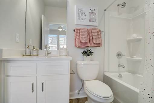 A white bathroom with a toilet, sink, and bathtub.