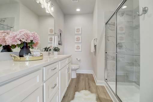 A white bathroom with a walk in shower.
