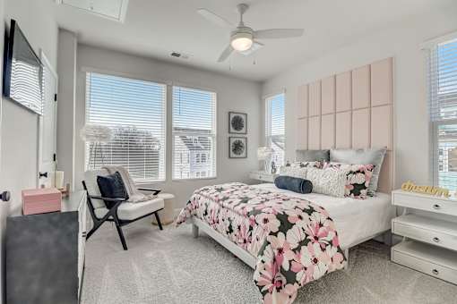 A bedroom with a large bed and a ceiling fan.
