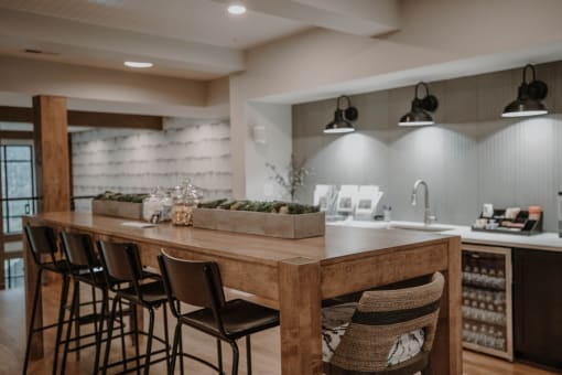 a kitchen with a long wooden counter and bar stools