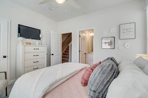A bedroom with a bed, dresser, and a television.