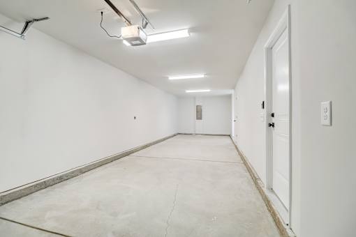 A long, empty hallway with a door at the end.
