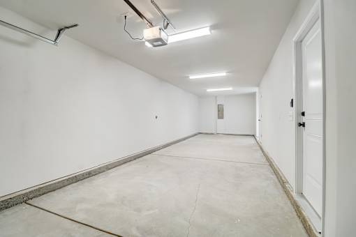 A long white hallway with a door on the right.