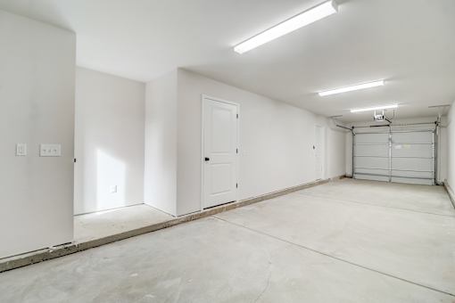 A large empty room with white walls and a concrete floor.