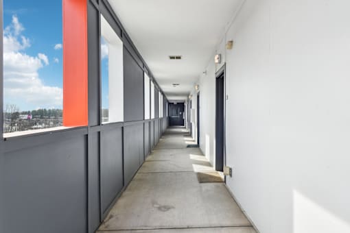 A long hallway with white walls and a concrete floor.