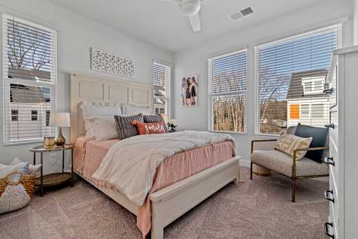 A bedroom with a large bed and a window with blinds.