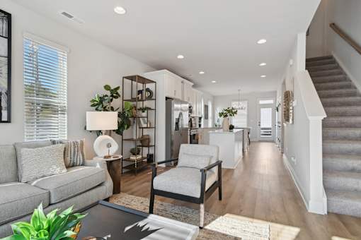 A well-lit, modern living room with a grey sofa and a wooden coffee table.