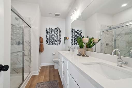 A bathroom with a white sink and a glass shower.