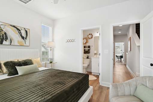 A bedroom with a large bed and a painting on the wall.