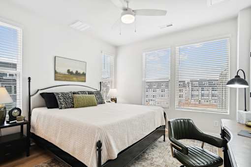 A bedroom with a large bed and a chair.