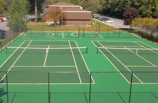 a tennis court with a building in the background