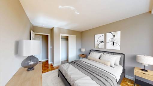 A bedroom with a bed, nightstands, and a lamp.