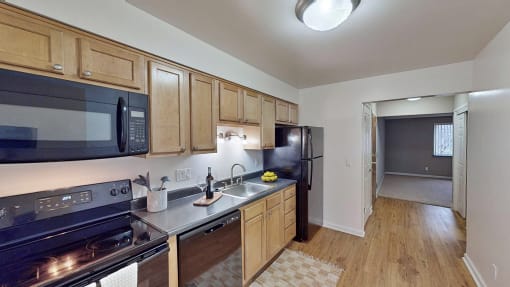 A modern kitchen with black appliances and wooden cabinets