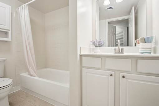 A white bathroom with a toilet, sink, and bathtub.