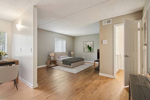 A bedroom with a bed, nightstand, and chair.