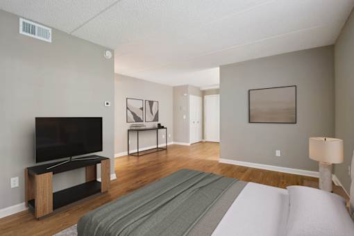 A bedroom with a bed, a television, and a lamp.