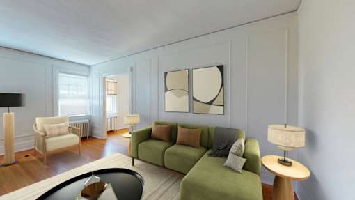 A living room with a green couch and a lamp.