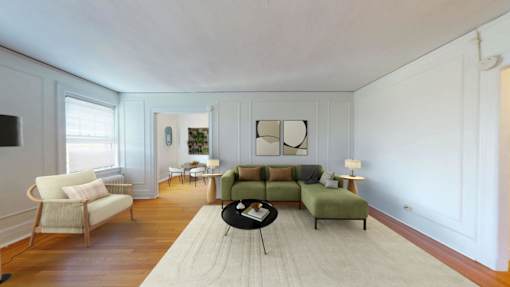 A living room with a white rug and a green couch.