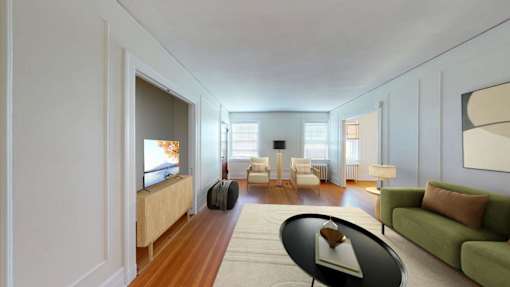 A modern living room with a green couch and a television.