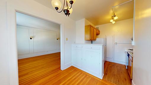 A kitchen with white cabinets and a wooden island.