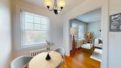A dining room with a table and chairs.