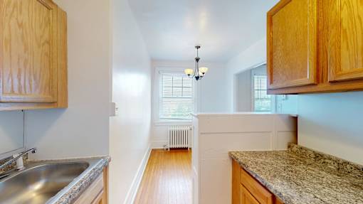 A kitchen with wooden cabinets and a granite countertop.