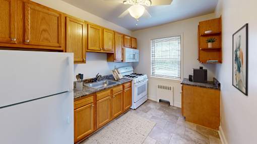 A kitchen with wooden cabinets and a white refrigerator.