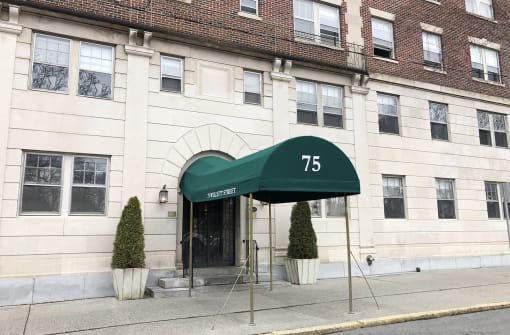 a green awning with the number 75 on it in front of a white building