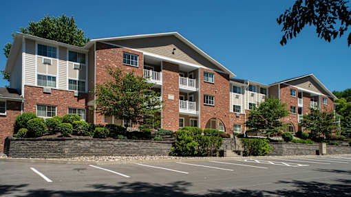 A large brick building with a parking lot in front.