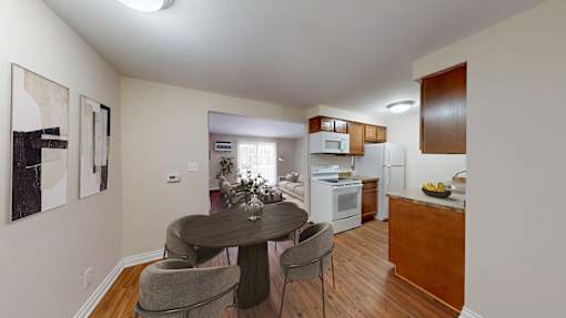 A dining room with a table and chairs.