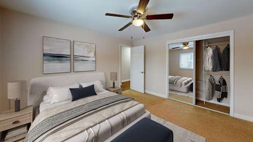 A bedroom with a large bed and a ceiling fan.
