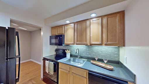 a kitchen with black appliances and wooden cabinets