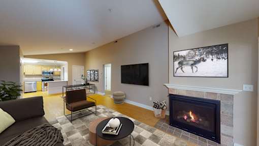 A living room with a fireplace and a painting of a deer on the wall.