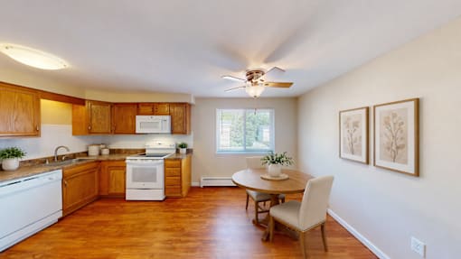 A kitchen with wooden cabinets and a white stove top oven.
